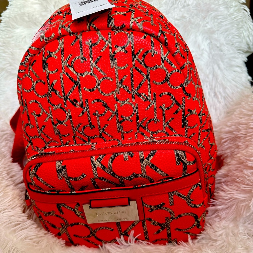 New  backpack at Calvin Klein red color printed worlds the name of the brand.